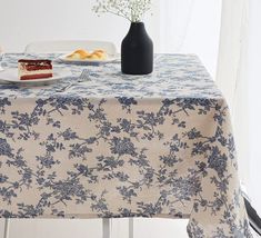 a table topped with a plate of cake and a vase filled with baby's breath