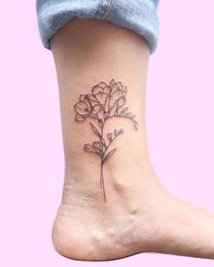 a small flower tattoo on the ankle