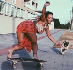 a woman riding a skateboard down a sidewalk next to a pug in a dress