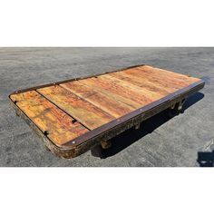 an old wooden table sitting in the middle of a parking lot with no one around it