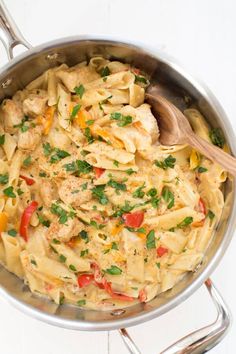 a pan full of pasta with chicken, peppers and parsley