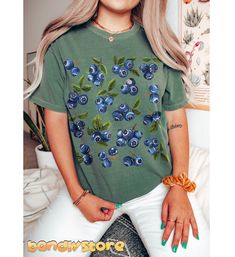 Treat yourself to this adorable Cute Blueberry Tshirt perfect for summer days! Printed on the trendy and loved by many Comfort Colors t-shirts, our Cottagecore Blueberry Shirt is oversized and so cozy, you'll never want to take it off. The Blueberry Print Tee features vintage styled blueberry clusters in a random pattern.  Embrace your love for all things cute and fruity with this Blueberry Tshirt!  It will be your most favorite summer tee! 🫐 💙 COMFORT COLORS 1717 Comfort Colors 1717 Unisex sh Spring Cotton Tops With Fruit Print, Cotton Fruit Print Tops For Spring, Cotton Tops With Fruit Print For Spring, Cute Summer Tops With Plant Print, Spring Fruit Print Crew Neck Tops, Cute Blue Screen Print Tops, Blue Cotton T-shirt For Summer, Summer Cotton Tops With Fruit Print, Summer Cotton Tops With Plant Print