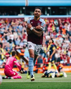 a soccer player is running with the ball in his hand and fans are watching from the stands