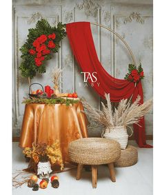 a table topped with lots of decorations next to a red drape covered chair and ottoman