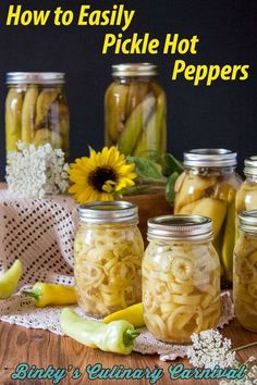 several jars filled with pickles sitting on top of a wooden table next to bananas and peppers