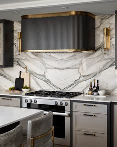 a kitchen with marble counter tops and gold trim on the hood above the stove top