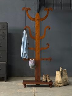 a coat rack with an umbrella and shoes on it next to a pair of boots