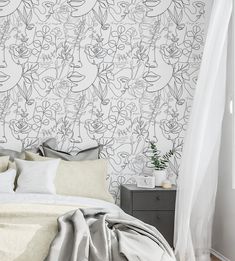 a bed with white sheets and pillows in front of a wallpapered headboard