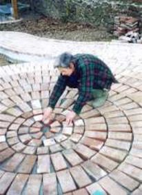 a man kneeling down on top of a brick circle