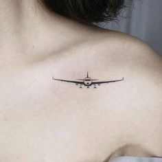 an airplane tattoo on the back of a woman's shoulder