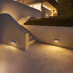 the stairs are lit up at night in front of a modern house with large windows