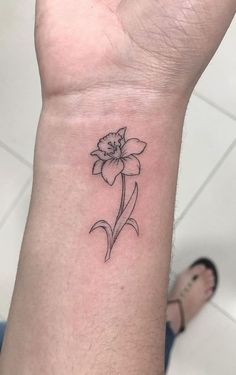 a small flower tattoo on the wrist