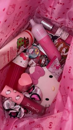 hello kitty cosmetics in a pink bag on a bed with hearts and bows around it