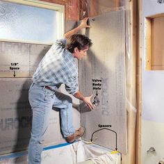 a man is working on the wall in his bathroom