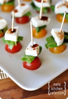 small appetizers with tomatoes, cheese and lettuce on a white plate