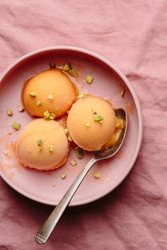 three desserts on a pink plate with a spoon