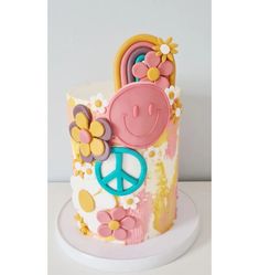 a peace sign and flower decorated cake on a plate