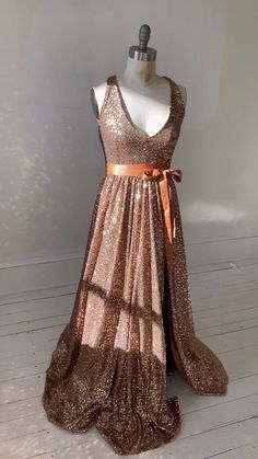 a dress that is on a mannequin with a brown ribbon around the waist