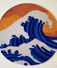 a round rug with an image of a wave in blue and orange colors on it