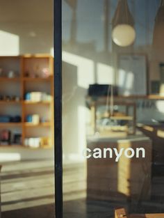 an empty store front with the name canyon on it's glass door and shelves in the background