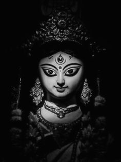 a black and white photo of a woman's face with an ornate headdress