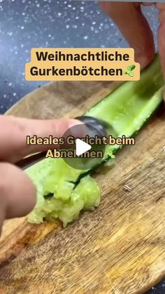 a person cutting celery on top of a wooden cutting board