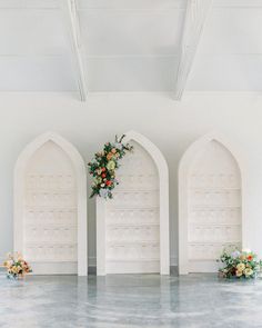 an empty room with white walls and arches