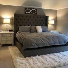 a large bed sitting in the middle of a bedroom next to two nightstands and lamps