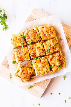 some food that is on top of a wooden cutting board and sitting on a table