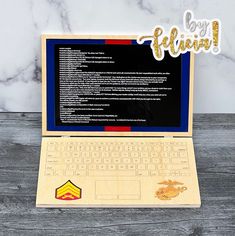 an open laptop computer sitting on top of a wooden table next to a white wall