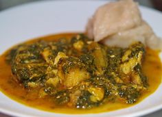 a white plate topped with chicken and spinach covered in sauce on top of a table