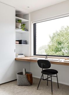 a chair sitting in front of a window next to a desk