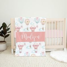 a baby crib bedding set with hot air balloons on it and the name madison