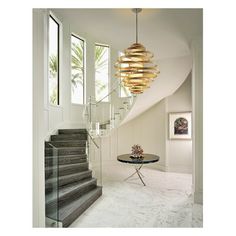 a round table sitting in the middle of a room next to a spiral stair case