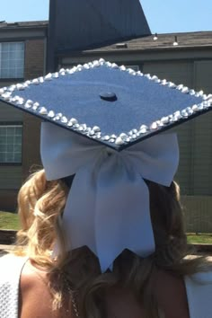 a woman wearing a graduation cap with pearls on it