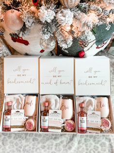 four bottles of perfume sitting in front of a christmas tree