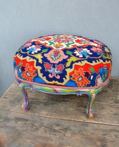 a colorful ottoman sitting on top of a wooden table