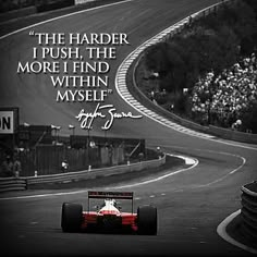 a man driving a race car down a track with a quote on the side of it