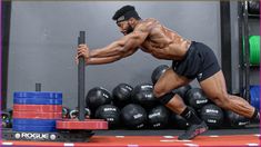 a man is doing push ups on a bar in front of some dumbbells