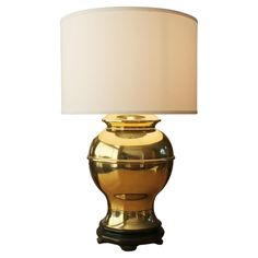 a gold lamp with a white shade on it