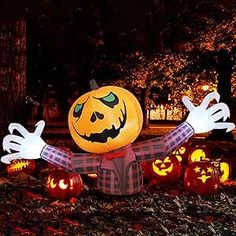 an inflatable pumpkin with arms and legs is surrounded by jack - o'- lanterns