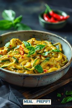 a bowl filled with pasta and vegetables on top of a wooden cutting board next to peppers