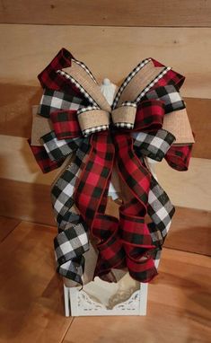 a large red and black plaid bow on top of a white box with burlocks