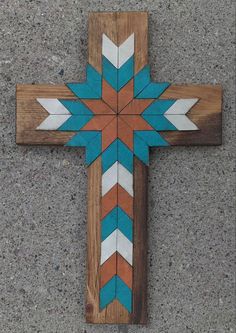 a cross made out of wood and painted with blue, orange and white stripes on it