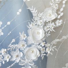 white flowers and pearls are on the fabric