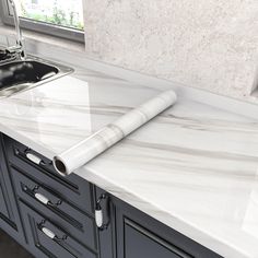 a kitchen counter with a roll of paper on top of it next to a sink