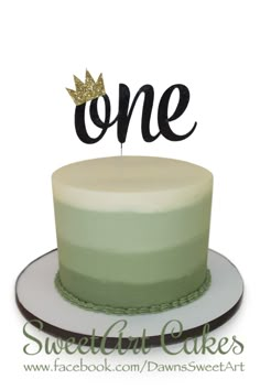 a cake with the word one on top and a single candle sticking out of it