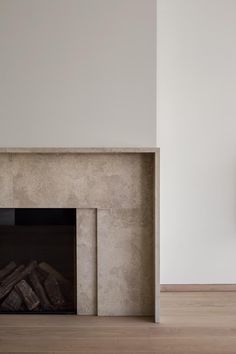 an empty room with a fire place and clock on the wall, next to a fireplace