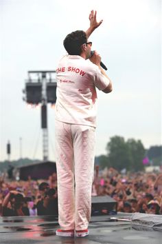 a man standing on top of a stage with his hands in the air