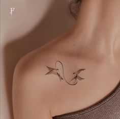 a woman with a tattoo on her shoulder that has two birds in the shape of a letter